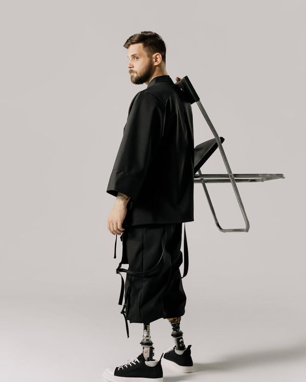 Man in a focused strength pose against a dark, minimalist background.